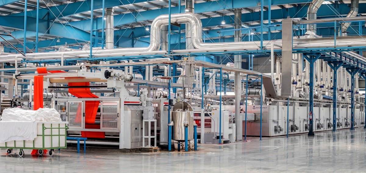 Industrial manufacturing facility with machinery and pipes, symbolizing Packages Group's diversified manufacturing operations